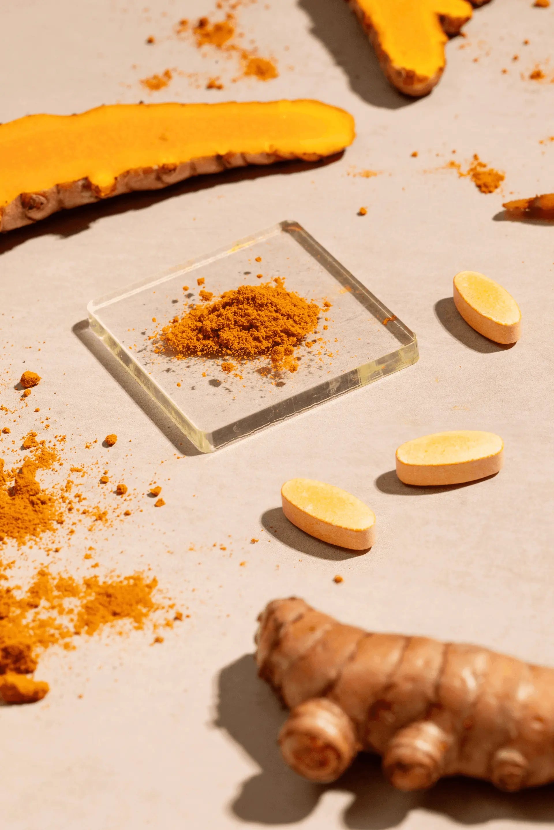 Turmeric root and ground turmeric powder on a light surface